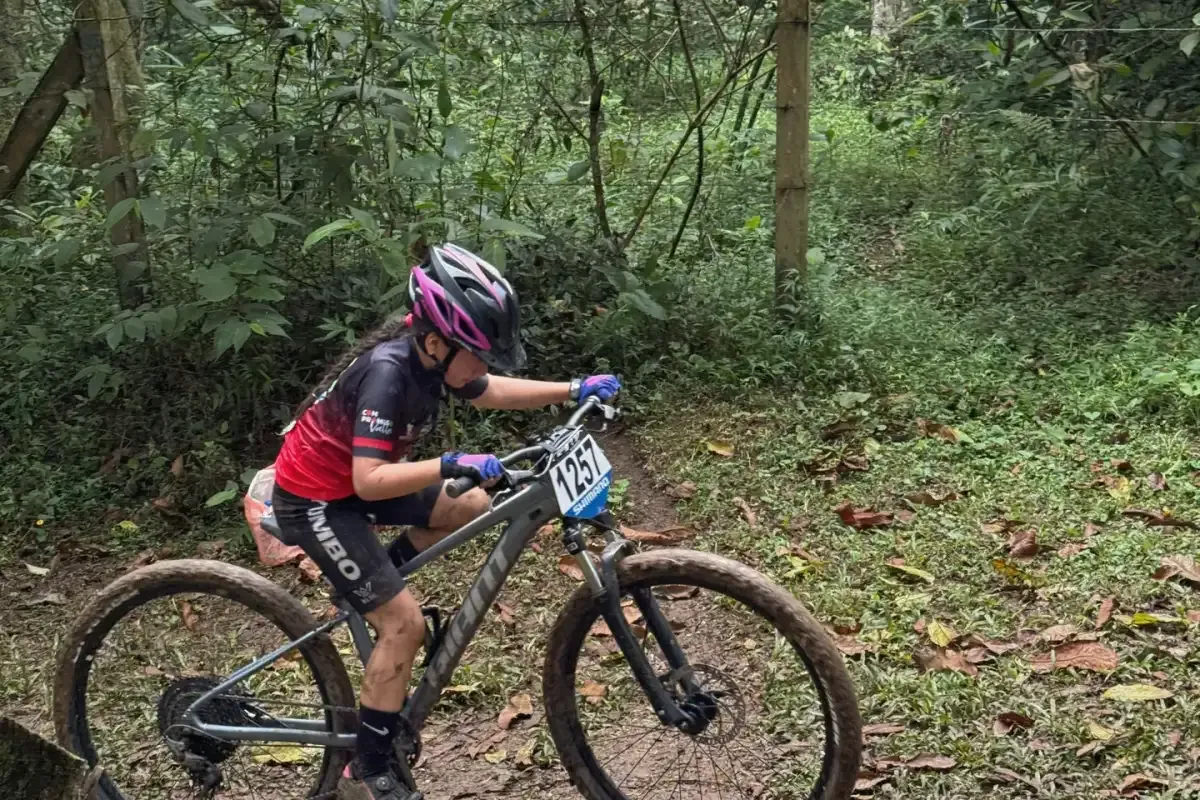 Corredora del club atacando una subida técnica en un circuito de XCO
