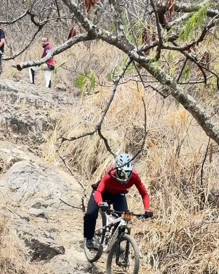 Juan Diego García del Club Trocha y Ruta baja por el mismo tramo de roca, con casco integral gris claro y camiseta roja, Copa Cali Bike Park, 2026