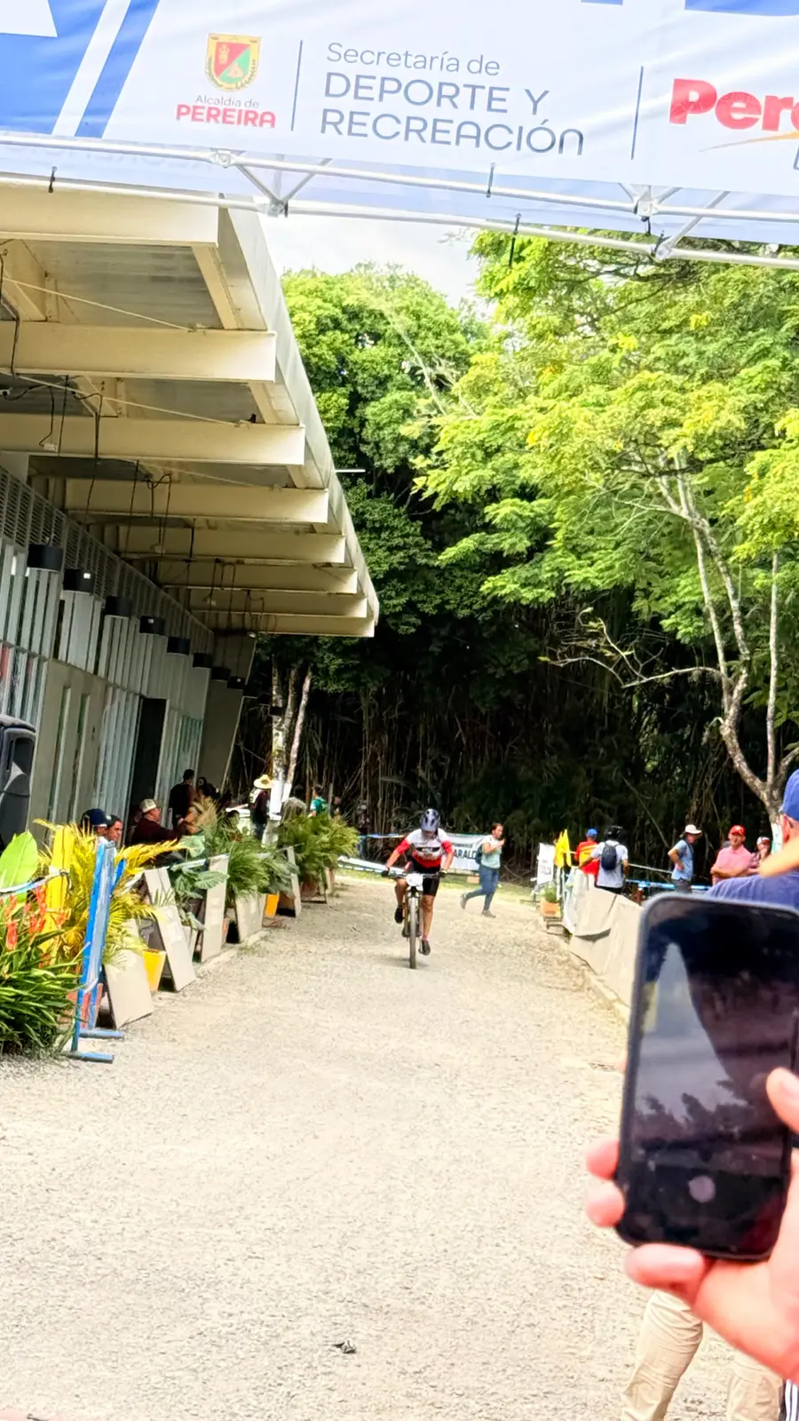 Isabel Quiñones llega en su bicicleta bajo el pórtico de meta del Nacional MTB 2026, con la pancarta de la Secretaría de Deporte y Recreación de Pereira de fondo